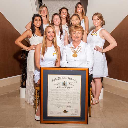 sorority women posing for installation photography with certificate